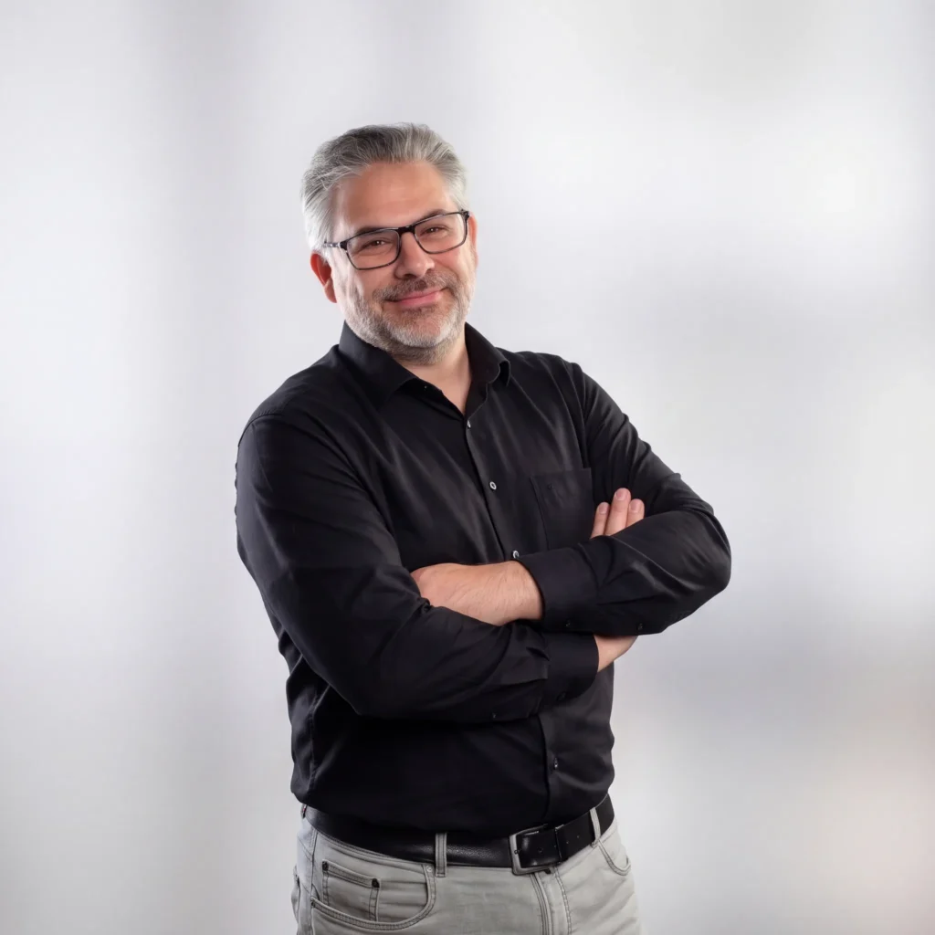 Porträt von Architekt Thomas Mischo in schwarzem Hemd vor hellem Hintergrund